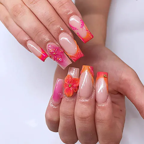 Nail design with orange tips and a painted hibiscus