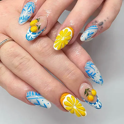 Almond nails painted with lemons and blue tiles